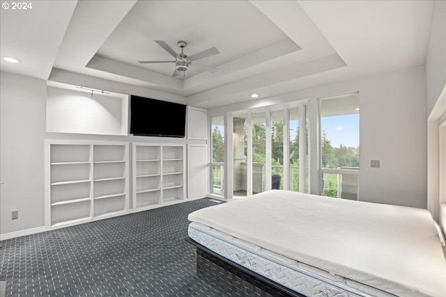 bedroom with ceiling fan, a tray ceiling, carpet flooring, and access to outside