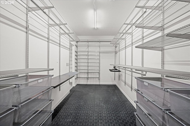 walk in closet featuring dark colored carpet