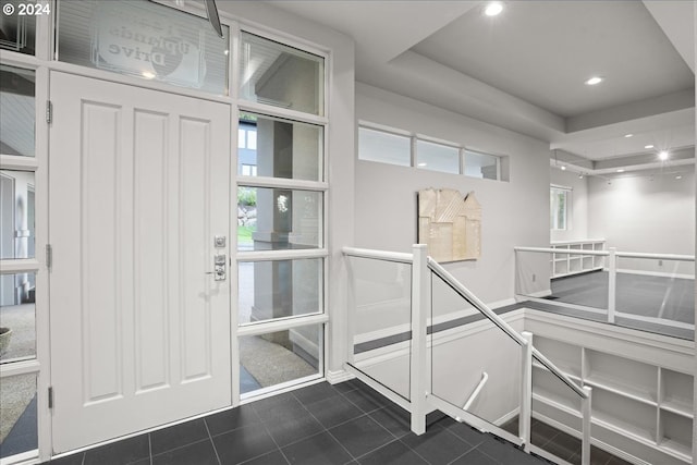 interior space featuring a raised ceiling and dark tile patterned floors