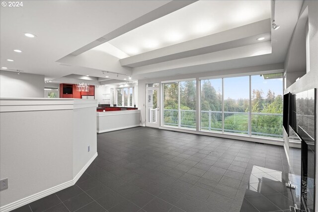 unfurnished living room featuring a raised ceiling