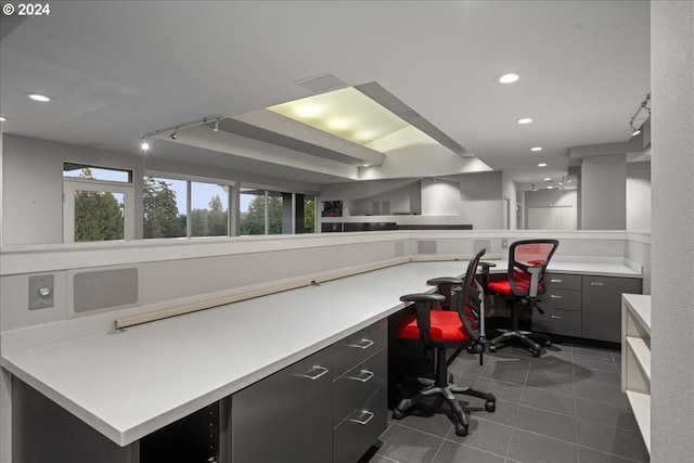 office featuring dark tile patterned flooring, built in desk, and track lighting