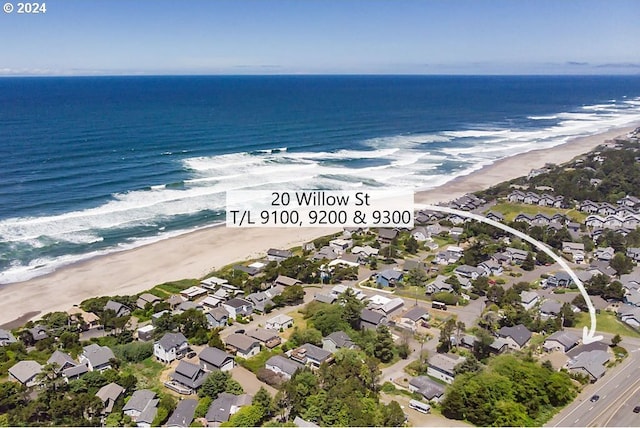 bird's eye view with a water view and a beach view