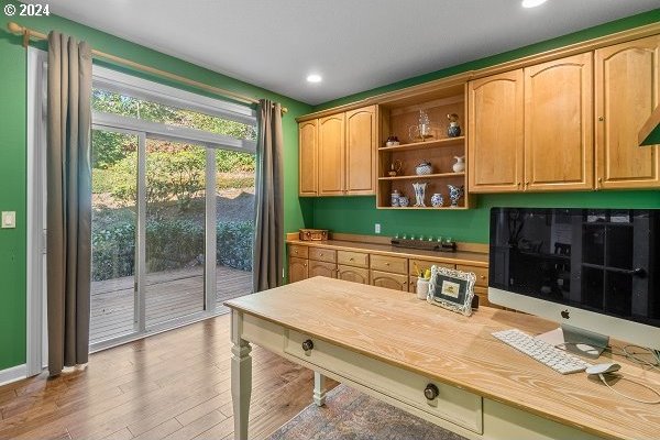 home office featuring hardwood / wood-style floors and built in desk