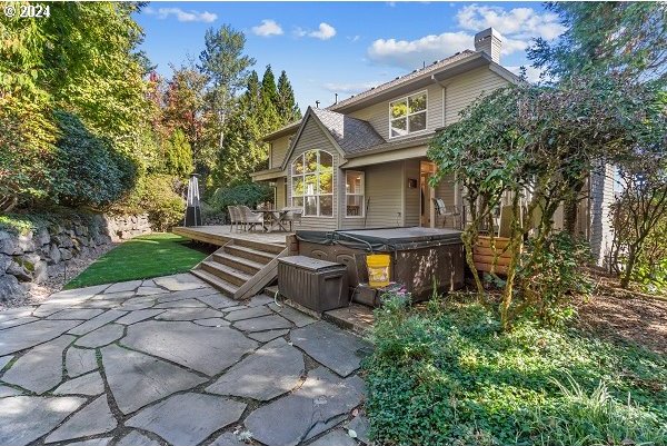 rear view of house featuring a hot tub and a patio