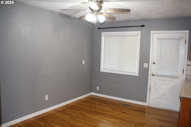 empty room featuring ceiling fan, hardwood / wood-style flooring, and a textured ceiling