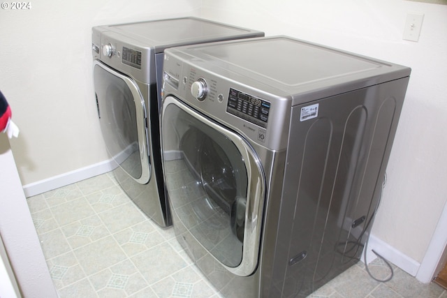 clothes washing area featuring light tile patterned flooring and separate washer and dryer