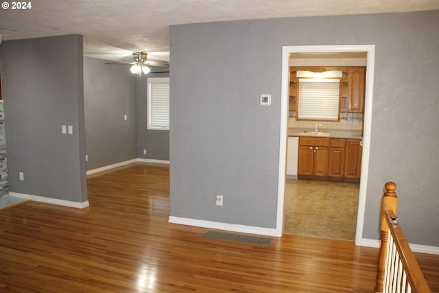 spare room featuring sink, hardwood / wood-style flooring, a textured ceiling, and ceiling fan