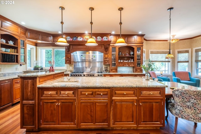 kitchen featuring light stone countertops, pendant lighting, and a healthy amount of sunlight