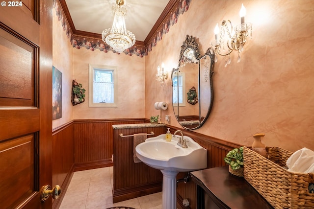 bathroom featuring tile patterned flooring, a notable chandelier, ornamental molding, and sink