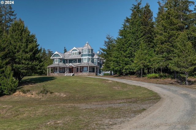 victorian home featuring covered porch and a front lawn