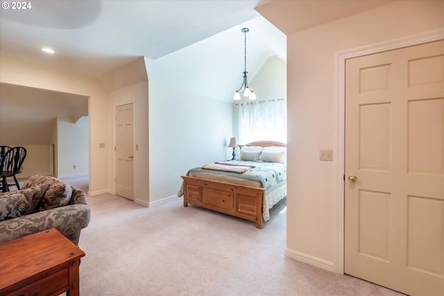 carpeted bedroom featuring a notable chandelier and vaulted ceiling