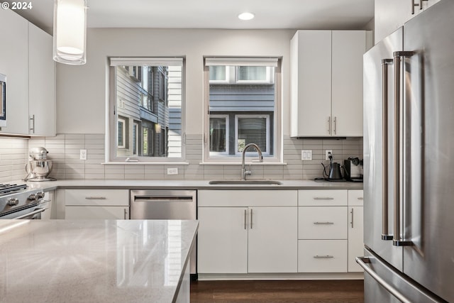 kitchen featuring backsplash, sink, dark hardwood / wood-style flooring, white cabinetry, and stainless steel appliances