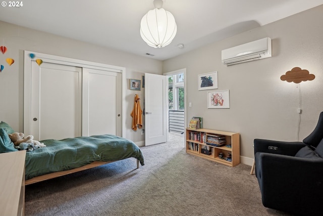 carpeted bedroom featuring a wall mounted AC and a closet