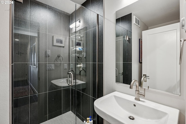 bathroom featuring sink and a shower with door