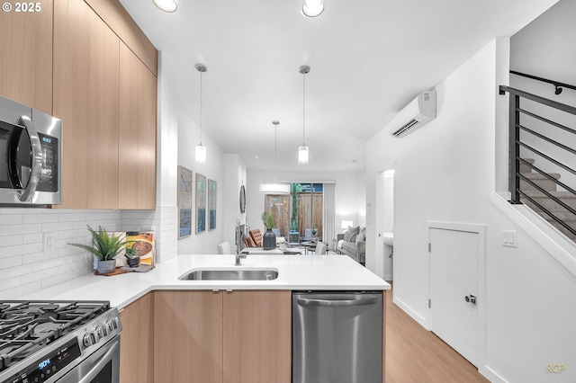 kitchen featuring appliances with stainless steel finishes, a wall mounted air conditioner, sink, decorative light fixtures, and backsplash