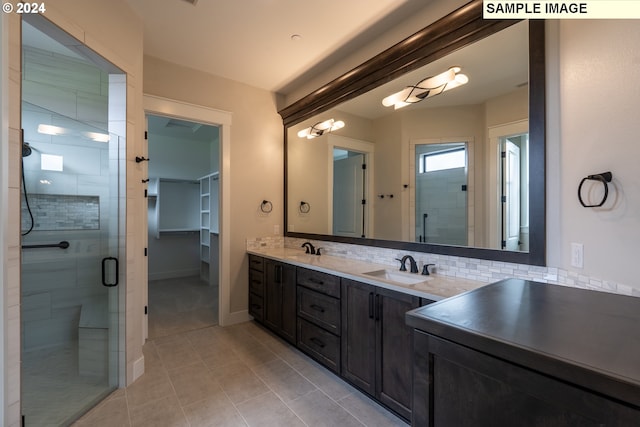 bathroom with decorative backsplash, tile patterned flooring, vanity, and an enclosed shower