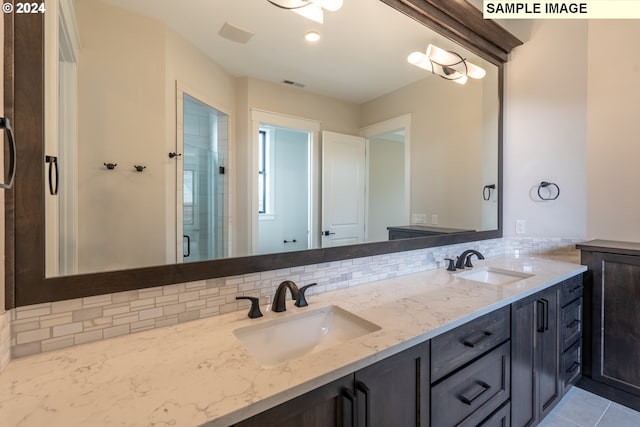 bathroom featuring vanity, backsplash, tile patterned floors, and a shower with door