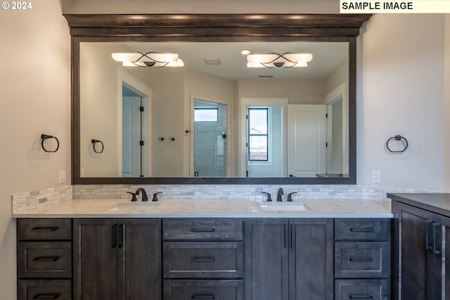 bathroom featuring tasteful backsplash, a shower with door, and vanity