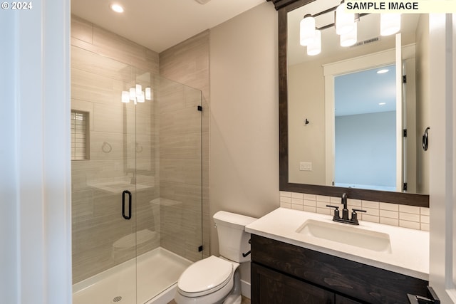 bathroom with decorative backsplash, toilet, walk in shower, and vanity