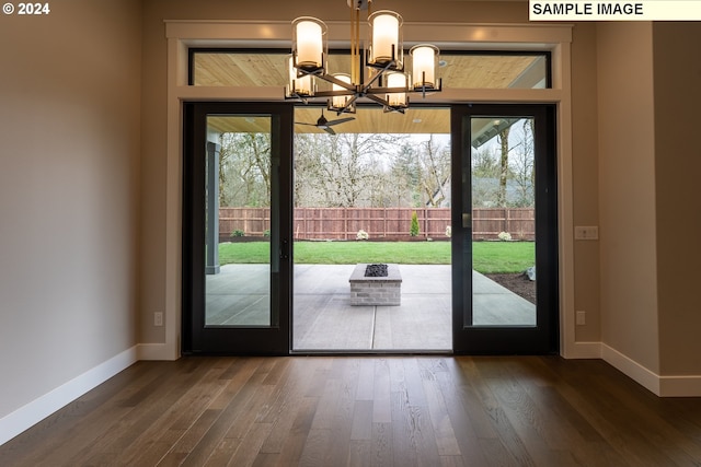 doorway featuring a chandelier, dark wood-type flooring, and a healthy amount of sunlight