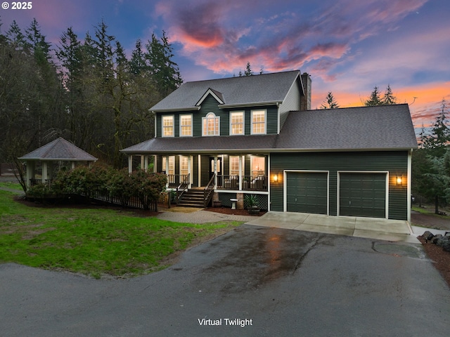 view of front facade featuring a porch, a garage, and a lawn