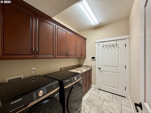 laundry room featuring cabinets, light tile patterned floors, a textured ceiling, and washer and clothes dryer