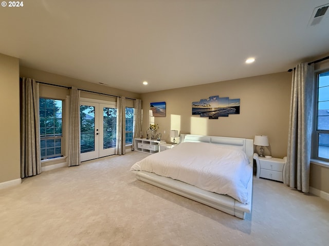 carpeted bedroom with french doors and multiple windows