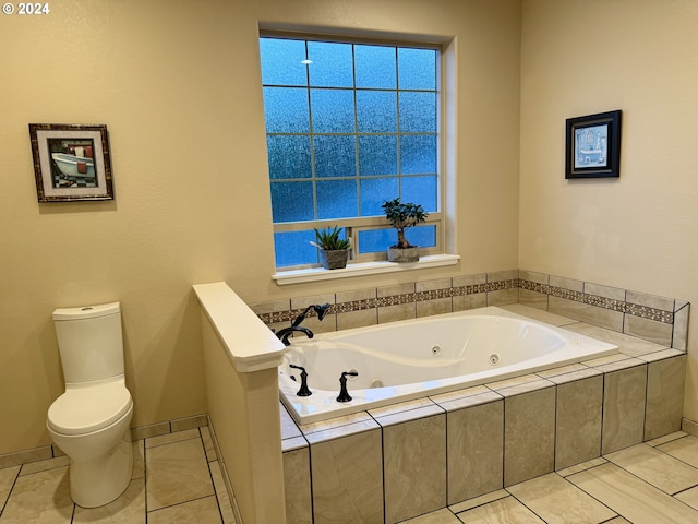 bathroom featuring tile patterned floors, tiled bath, and toilet