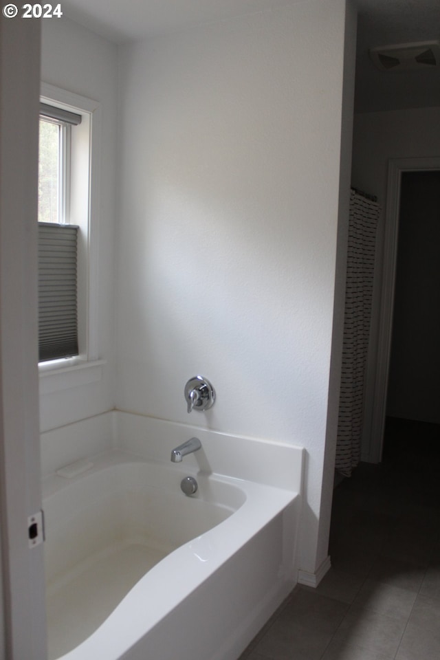 bathroom with a bathtub and tile patterned flooring