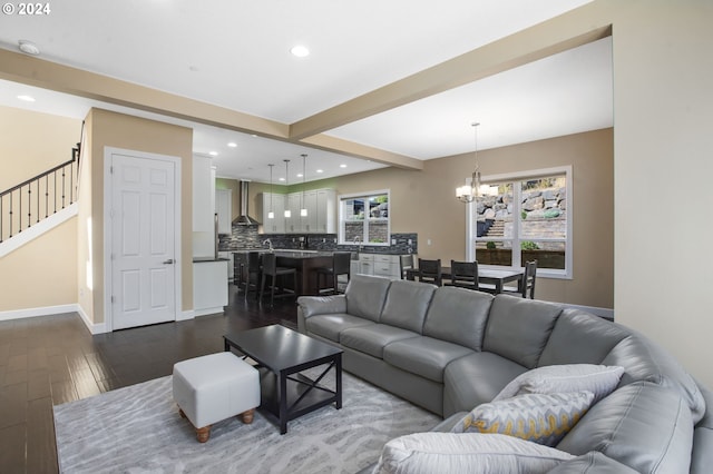 living room featuring hardwood / wood-style floors, a notable chandelier, and beam ceiling