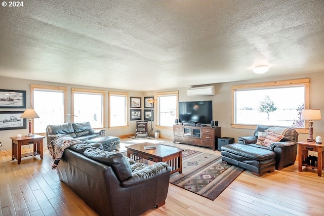 living room featuring wood finished floors, a wall mounted air conditioner, and a textured ceiling