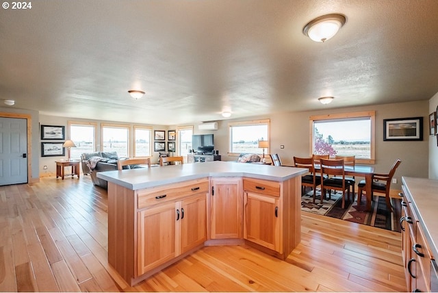 kitchen featuring open floor plan, light brown cabinets, light countertops, and light wood-style floors