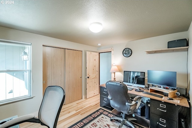 office space with a textured ceiling and light wood finished floors