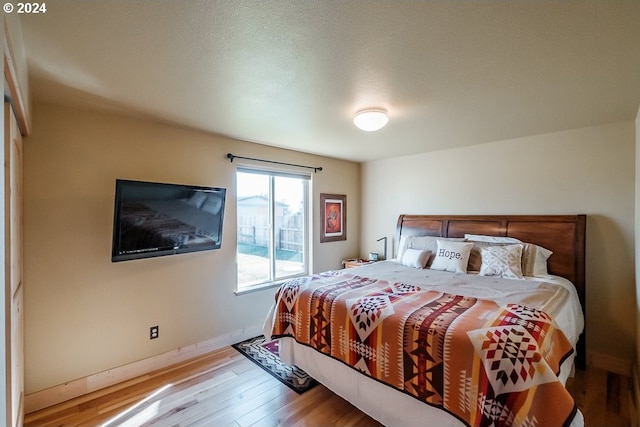 bedroom featuring baseboards and wood finished floors