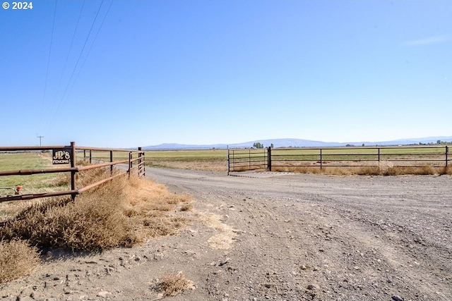 view of road with a rural view and a mountain view