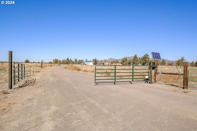 exterior space featuring a rural view, a gated entry, and a gate