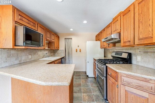 kitchen with backsplash, stainless steel appliances, dark tile patterned floors, sink, and kitchen peninsula