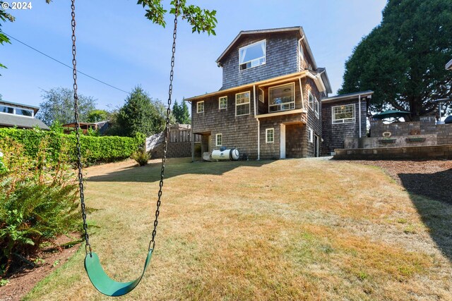 rear view of property featuring a lawn