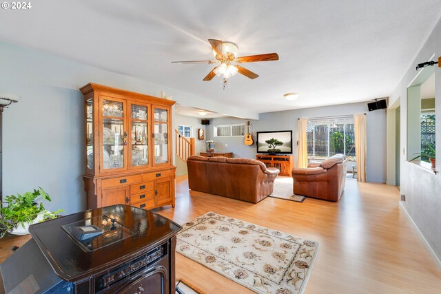 living room with light wood-type flooring and ceiling fan