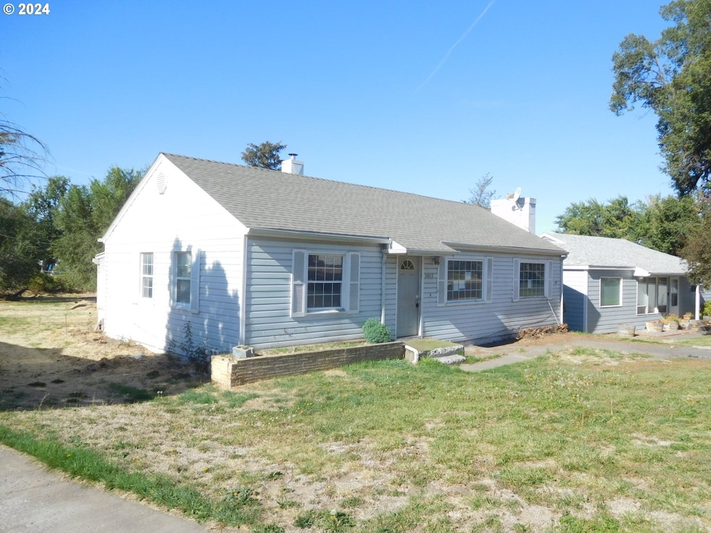 single story home featuring a front lawn