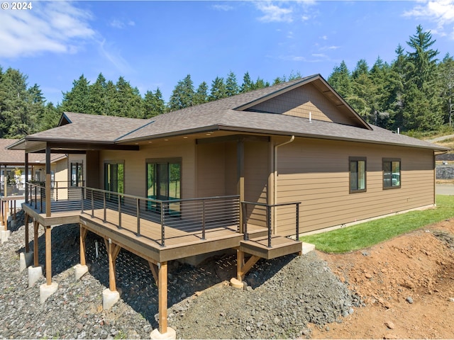 view of front of property featuring a deck and a shingled roof