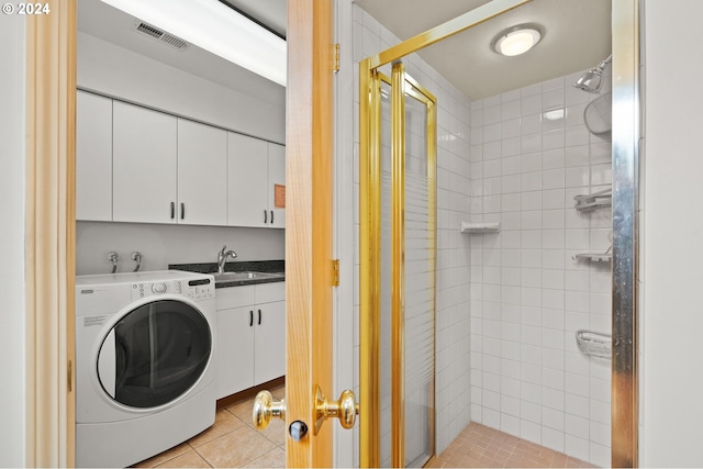 washroom featuring washer / dryer, light tile patterned floors, cabinet space, visible vents, and a sink