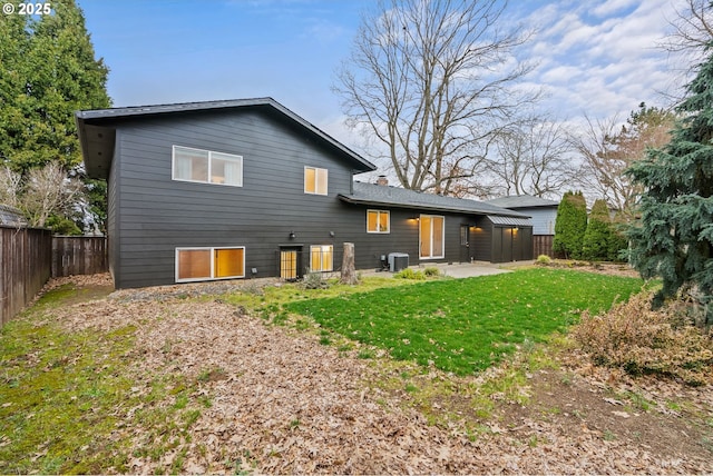 rear view of house featuring a patio area, a yard, a fenced backyard, and central air condition unit