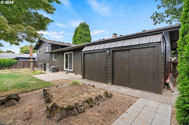 rear view of house with central AC unit, a yard, fence, and a patio