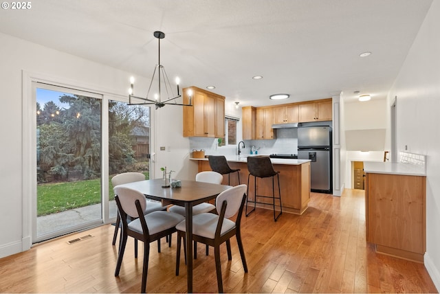 dining area with light wood-type flooring, visible vents, and recessed lighting