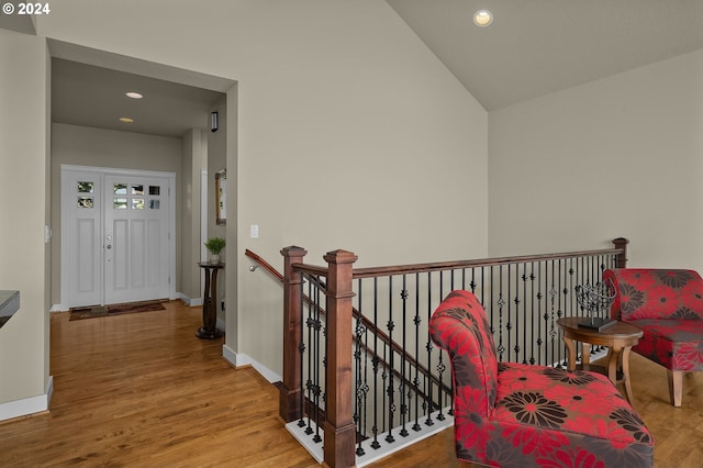 hall with hardwood / wood-style floors and vaulted ceiling