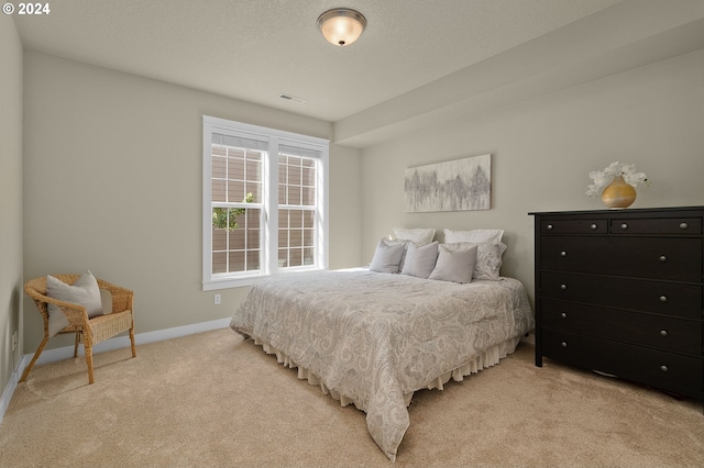 bedroom featuring a textured ceiling and light carpet