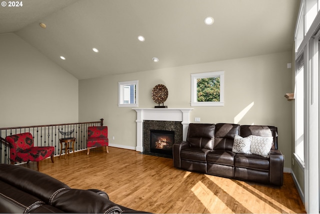 living room with a wealth of natural light, light wood-type flooring, and lofted ceiling