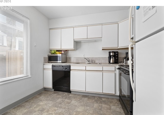 kitchen featuring sink, black appliances, and white cabinetry