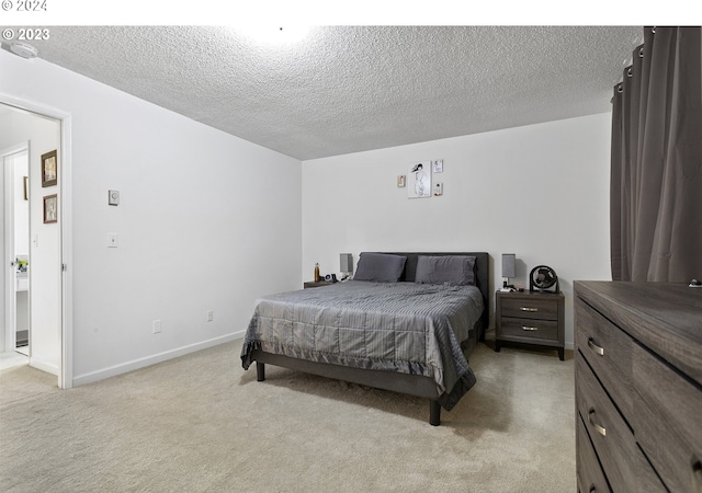 bedroom with a textured ceiling and light colored carpet